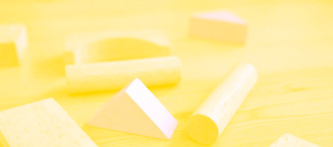 Wooden geometric shapes on a bright table visually symbolize building blocks of photographic confidence. This image connects the concept of foundation and growth to each step in boosting your skills as a photographer—perfect for illustrating practical advice and positive transformation.